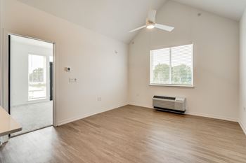 A room with a ceiling fan and a window with blinds